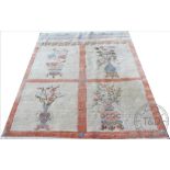 A Chinese wool carpet, worked with four panels of vases of flowers,