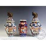 A pair of Continental imari decorated octagonal vases and covers, each surmounted with a Dog of Fo,