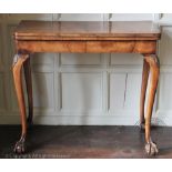 A walnut card table on cabriole legs and claw and ball feet, 76cm H x 84cm W x 42.