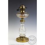 A Victorian cut glass oil lamp, with faceted reservoir and column, on brass base,