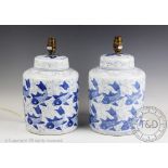 A pair of modern blue and white table lamps, modelled as ginger jars and covers decorated with carp,