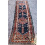 A Caucasian wool runner, worked with geometric motifs against a blue ground,