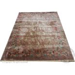 A Chinese carpet, worked with a floral design against a beige ground,