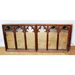 An ecclesiastical carved oak panel converted to a mirror, with six arched sections,