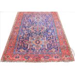 A Caucasian wool carpet, worked with geometric motifs against a blue ground,