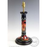 A Moorcroft candlestick converted to a lamp base in a poppy pattern,