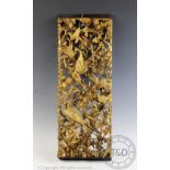 A Chinese carved and gilt wood panel, decorated in high relief with birds among prunus flowers,