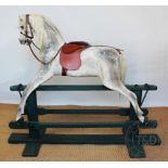 A large dapple grey rocking horse by Lines Brothers, on a green painted base,