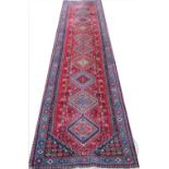 A Caucasian wool runner, worked with ten hooked gulls against a red ground, 390cm x 83cm,
