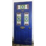 An Edwardian blue painted front door, with brass door furniture and three stained glass panels, 198.
