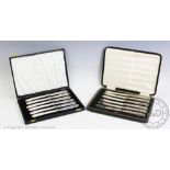Two cased sets of six silver handled butter knives,