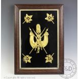 A cased set of five military gilt metal mounts, the central mount cast as a trophy of arms,