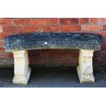 A reconstituted stone garden bench, with curved top and scroll ends,