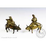 Two similar bronze koro and covers, each designed as a man seated upon a buffalo,