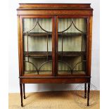 An Edwardian inlaid mahogany display cabinet, with two astragal glazed doors, on taped square legs,