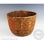 A Native American Indian basket, of cylindrical form and weaved in a geometric design,