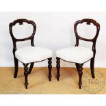 A set of six Victorian walnut dining chairs, with serpentine backs and upholstered seats,