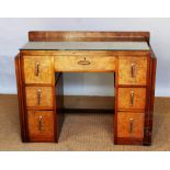 An Art Deco walnut and burr walnut dressing table, with an arrangement of seven drawers,