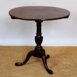 A Regency mahogany circular occasional table, with tilt op, on a carved column and tripod base,