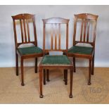 A set of eight Edwardian Arts and Crafts oak dining chairs, with green upholstered seats,