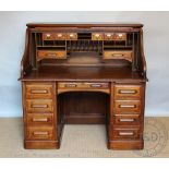 An Edwardian oak roll top desk, with tambour enclosing a fitted interior,