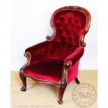 A Victorian carved mahogany salon chair, with button back upholstery,