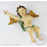 A gilt wood and gesso cherub, carved in flight scantily clad and with gilt painted wings,