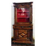 A 19th century French walnut cabinet, with glazed door enclosing shelves, above a drawer,