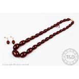 A cherry amber necklace, with twenty nine graduated beads, largest bead 2.