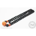 A carved coral coloured and black bead vintage necklace,