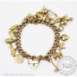 A Victorian 9ct yellow gold curb link bracelet, hung with numerous charms, including; an oil lamp,