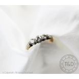 A three stone diamond ring, designed as three graduated brilliant cut diamonds,