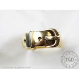 A 9ct yellow gold buckle ring, designed as a broad band with buckle detail, size O, weight 8.