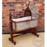 An early Victorian mahogany cradle, with caned hood and sides, on turned and block stand,