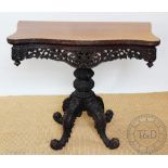 A 19th century Anglo - Indian / Burmese carved hardwood tea table, of serpentine form,