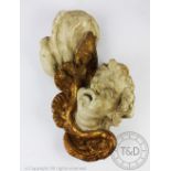 A gilt wood and gesso carving of a cherubs mask and wing,