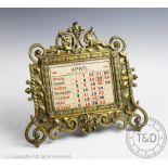 A Victorian cast brass calendar, with elaborate scroll frame and month card inserts for 1935,