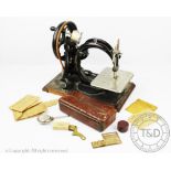 A late 19th/early 20th century Willcox & Gibbs sewing machine, on a wooden base,