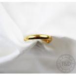 A 22ct gold wedding band, incised to the interior, size K, gross weight 3.