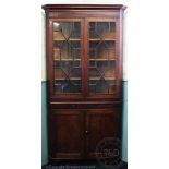 A George III oak corner cabinet, with two astragal glazed doors, above two cupboard doors,