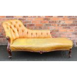 A Victorian carved rosewood chaise longue, with button back tan leather upholstery, on scroll legs,