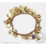 A 9ct yellow gold curb link bracelet, hung with numerous charms, including a horseshoe, a bible,