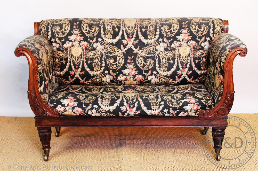 An early 19th century carved rosewood scroll end settee / day bed, on carved and turned legs,