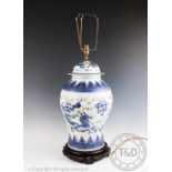 A Chinese porcelain lamp, modelled as a vase and cover, on carved hard wood stand,