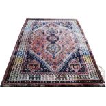 A Caucasian wool rug, worked with geometric motifs against a pale red ground, 210cm x 150cm,