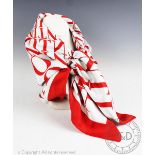 A Valentino silk scarf, in a red logo design against an ivory ground within red border,