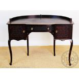 An Edwardian mahogany ladies writing table, of curved form, with a drawer and two cupboard doors,
