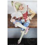 A large Austrian commedia dell'arte / opera pottery figure of a seated jester,