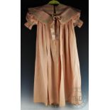 A blush pink silk childs cape, with chemical lace trim, and pleated back with over collar detail,