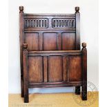 A pair of 17th century style oak single beds, with panelled head and foot boards,